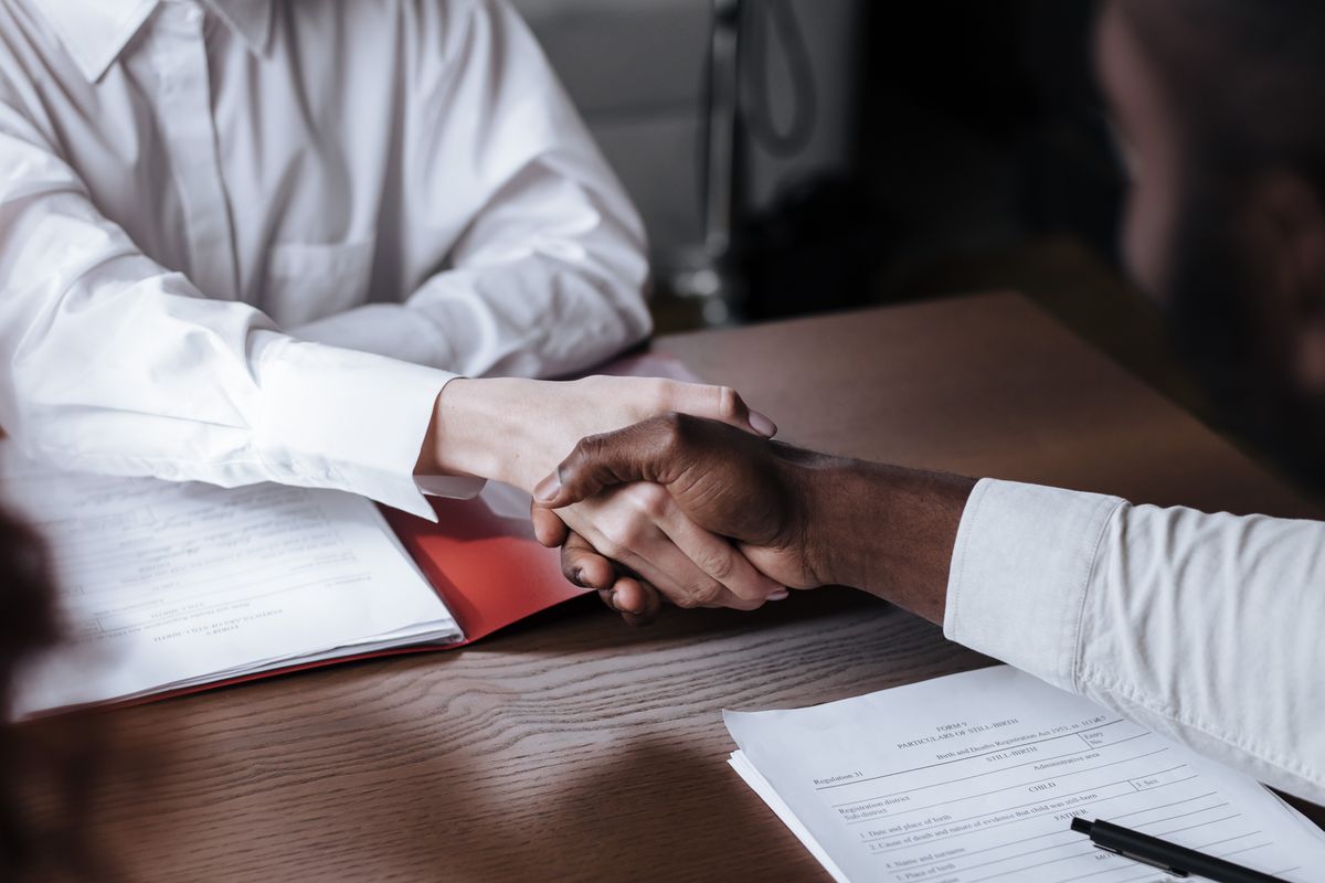 Business handshake over a contract, symbolizing a bonded agreement