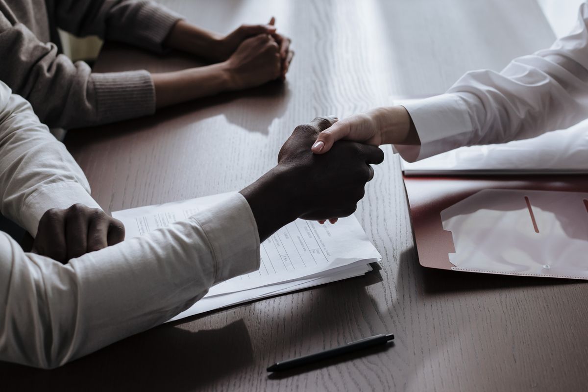 Handshake over signed contract documents at a business meeting